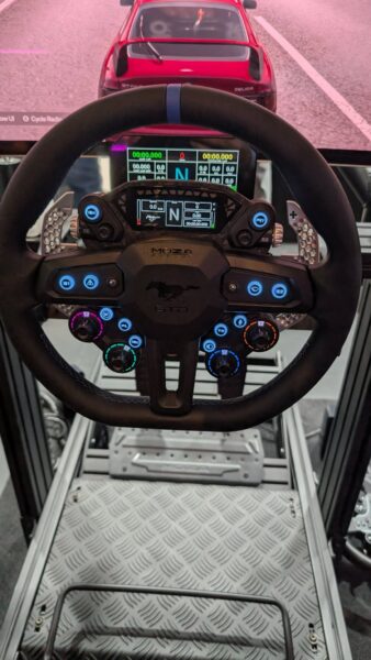 MOZA x Ford Mustang GTD steering wheel in use on a sim rig at Gamescom 2026, showing the Mustang badge and paddle shifters